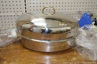 Photo of the stainless steel Premier Performance dome roaster with gold-tone handle on a wooden surface.