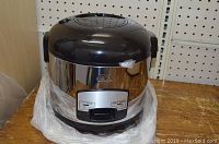 Wolfgang Puck stainless steel and black 7 cup electric rice cooker on wooden surface