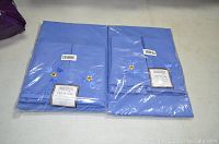 Two unopened blue Temp-Tations Old World tablecloth packages each containing one tablecloth and eight napkins.