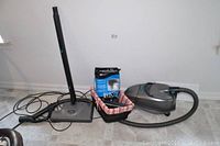 TriStar canister vacuum with wand, hose, power head, and vacuum bags laid out on floor.