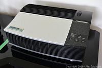 Full view of the Oreck XL Professional Air Purifier showing the vented black bottom half and white top half with control panel on top right corner.