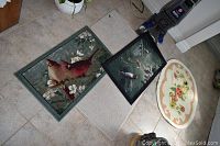 View of all four mats placed on tile floor including bird, floral, and plain designs.