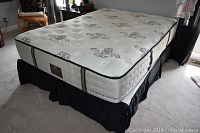 Full view of mattress on frame with bed skirt