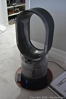Front view of Dyson humidifier showing loop amplifier, clear water tank, black base, illuminated power button.