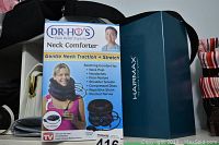 Dr. Ho's Neck Comforter box with images and text describing neck traction benefits and usage next to HairMax box