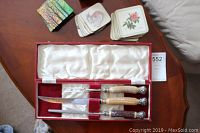 Photo of Birks boxed carving set with three ornate-handled knives and four sets of decorative coasters.