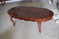Full view of the coffee table showing scalloped edges, Queen Anne legs, and the cherry stained finish on the wood top.