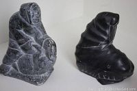 Two Inuit stone carvings on white background, showing Eskimo figure and walrus side by side.