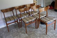 Six teak dining chairs arranged in two rows