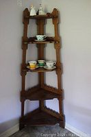 Wooden corner what not shelf with five shelves holding various porcelain items