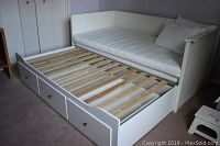Full view of assembled white day bed with upper mattress and extended trundle below