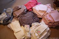Multiple stacks of folded double-sized sheets in various solid colors and floral patterns.