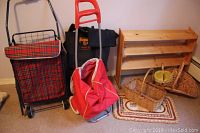 Full lot shot showing two wheeled shopping carts with fabric bags, wooden shoe rack, three wicker baskets, and braided rope mat