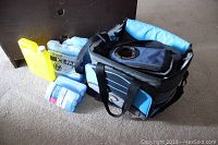 Two insulated soft-sided cooler bags with four freezer ice packs grouped together on carpeted floor under diffused light.
