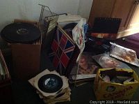 Crates and boxes of vinyl records and singles with scattered album sleeves across the floor