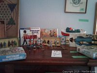 Overview of table showing boxed model kits, loose figures and tugboat