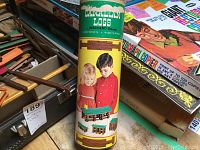 Vintage Canadian Logs cylindrical box with label showing children playing with logs and model example.