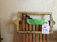 Vintage wooden blanket dryer mounted on a wall showing its frame and slats.