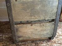 Close-up view of wooden planks and metal strip reinforcement along the side edge of the brick mould.