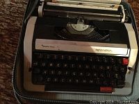 Close-up of Remington Rand portable typewriter with QWERTY keyboard shown inside a carrying case.