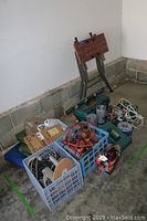 Wide view of work table and various tools grouped together on floor in garage corner.