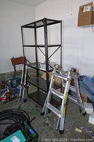 Full view showing the metal shelving unit, hand cart leaning against the wall, and Gorilla ladder in front.