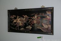 Frontal view of carved stone and wood wall art panel hung on wall