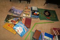 Photo of collection of vintage games, book, and roulette wheel on carpeted floor