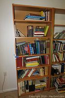 Wide view of bookshelves filled with assorted books of various sizes and titles.