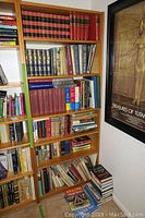 Bookshelves filled with assorted history, fiction, and reference books including a lot of hardcover volumes and some paperback.