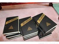 Stack of 16 black hardcover books, labeled Arabian Nights volumes 1-10 and Supplemental Nights volumes 1-6, arranged in three piles on floor.