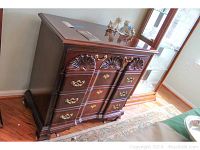 Side perspective of the Thomasville wooden server showing overall shape, finish and four drawer arrangement with brass hardware and carved accents.