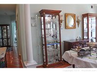 Full view of curio cabinet with beveled glass and wood frame, showing size and placement.