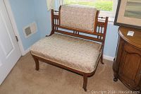 Full view of the Eastlake style settee showing wooden frame and floral upholstery.