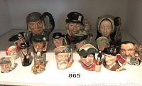Front view of a set of 15 Royal Doulton Toby mugs featuring various characters including historical and fictional figures, showing colors, facial expressions, and detail.
