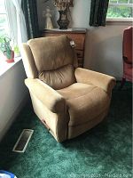 Front angle view of La-Z-Boy tan fabric rocker recliner chair positioned near window.