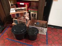Full overview of the lot showing mason jar boxes, jelly jars, and two black graniteware pots with lids.
