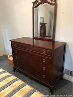 Front angle of vintage wooden dresser with attached mirror detail.