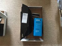 Black speaker with dock and remote control inside a box with label 365.