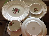 Top view of several Wedgwood Moss Rose pattern dishes including plates, bowl, cup, and saucer.