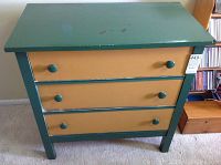 Front view of the three drawer dresser painted green and mustard yellow.