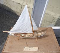 Full side view of the New Bedford whale boat model displayed on a wooden base with a plaque.