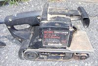 Side view of the Sears Craftsman belt sander showing model information and motor specs on a label.