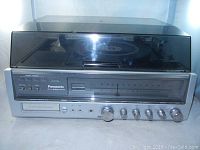 Full frontal view of the Panasonic turntable with closed dust cover showing overall condition and controls.