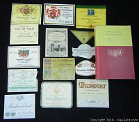 Overview of all thirteen vintage wine labels and the 1964 Frank Shoemaker's Encyclopedia of Wine hardcover book. Labels vary in size and include various producers and appellations, with some showing minor folds or wear.
