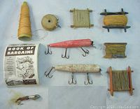 Photo showing 4 fishing lures, 6 wooden spools with fishing line, and a vintage paper catalog titled 'Book of Bargains'