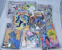 Photo showing a collection of vintage Marvel and DC comic books including Nightcrawler, Spider-Man, The Pact, and others.
