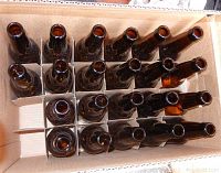 Top view showing 46 amber glass beer bottles arranged in cardboard packaging.