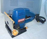 Side view of Ryobi blue biscuit joiner showing power cord, handle, base plate, and adjustment knob with Ryobi branded carrying case partially visible behind.