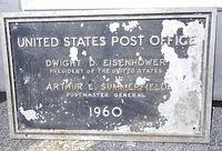 Front of the rectangular metal plaque with embossed text relating to the 1960 United States Post Office, mentioning Dwight D. Eisenhower and Arthur E. Summerfield.